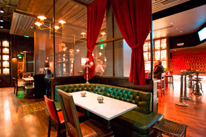 La Biblioteca - 90 reception <br> Shelves of Tequila, rich leather banquettes dramatic red satin curtains and lounge tables create an exclusive ambiance for cocktails and Latin-Asian cuisine.